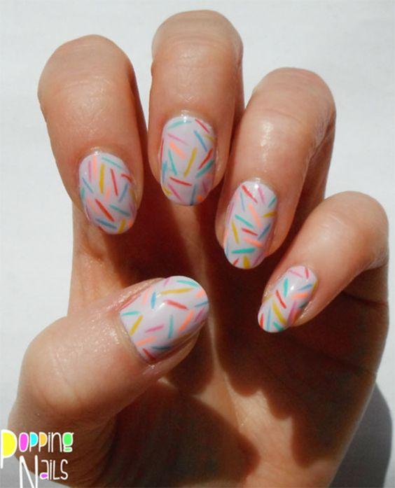 Imagem mostra nail art com traços coloridos
