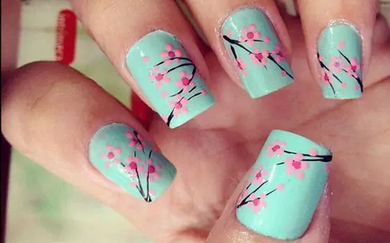 Imagem mostra unhas com nail art floral
