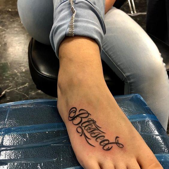 Imagem mostra tatuagem no pé escrita