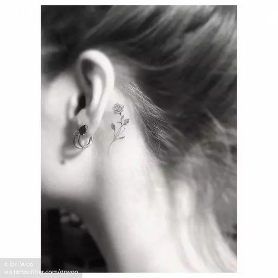 Imagem mostra tatuagem atrás da orelha de flor