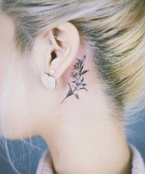 Imagem mostra tatuagem atrás da orelha de flor
