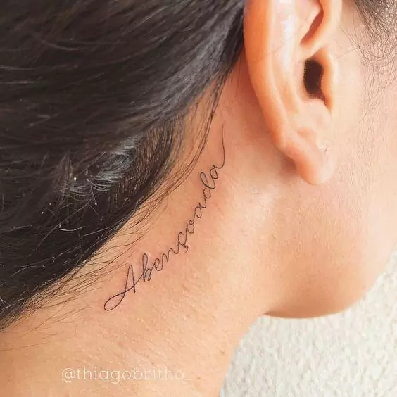 Imagem mostra tatuagem atrás da orelha escrita