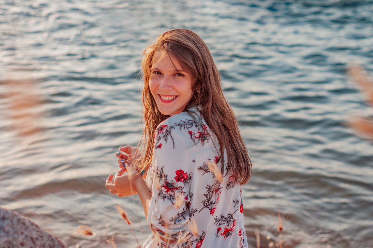 Mulher sorrindo em frente ao mar