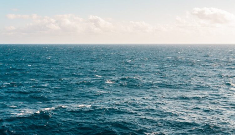 Mar azul, calmo e tranquilo com céu azul ao fundo