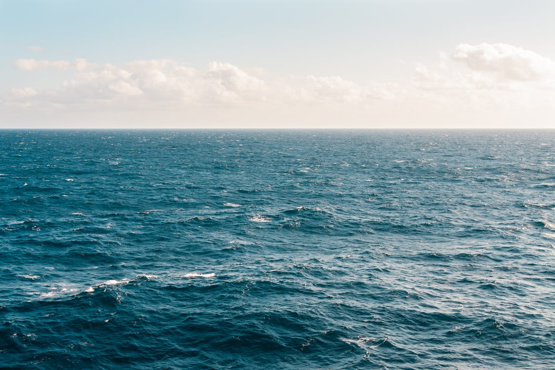 Mar azul, calmo e tranquilo com céu azul ao fundo