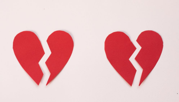 Dois corações vermelhos de papel partidos ao meio, indicando separação