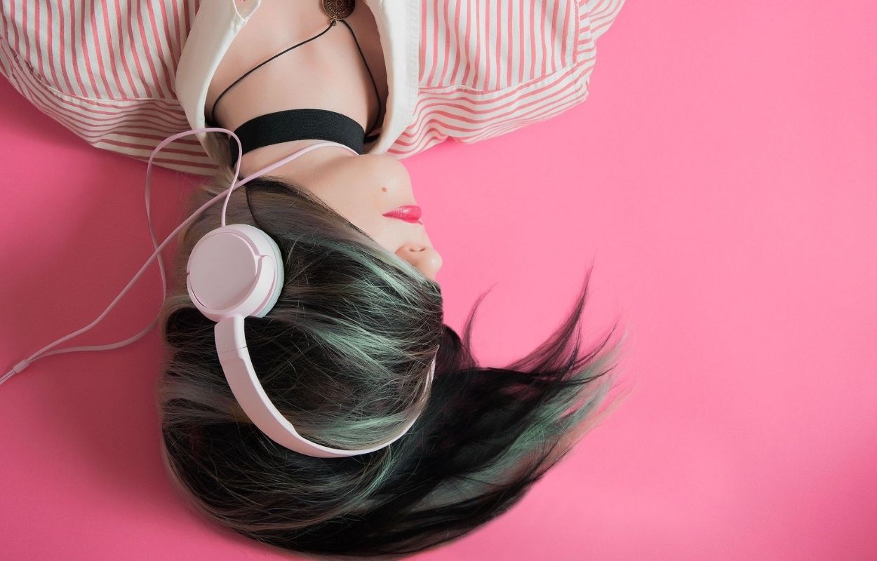 Imagem mostra mulher com fones de ouvido - frases de música