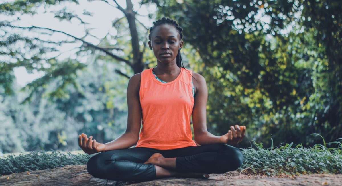 a imagem mostra uma mulher sentada em postura meditativa