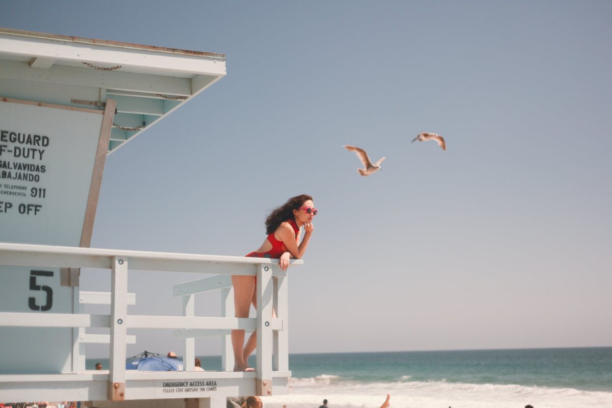 foto mostra mulher de maiô vermelho na praia
