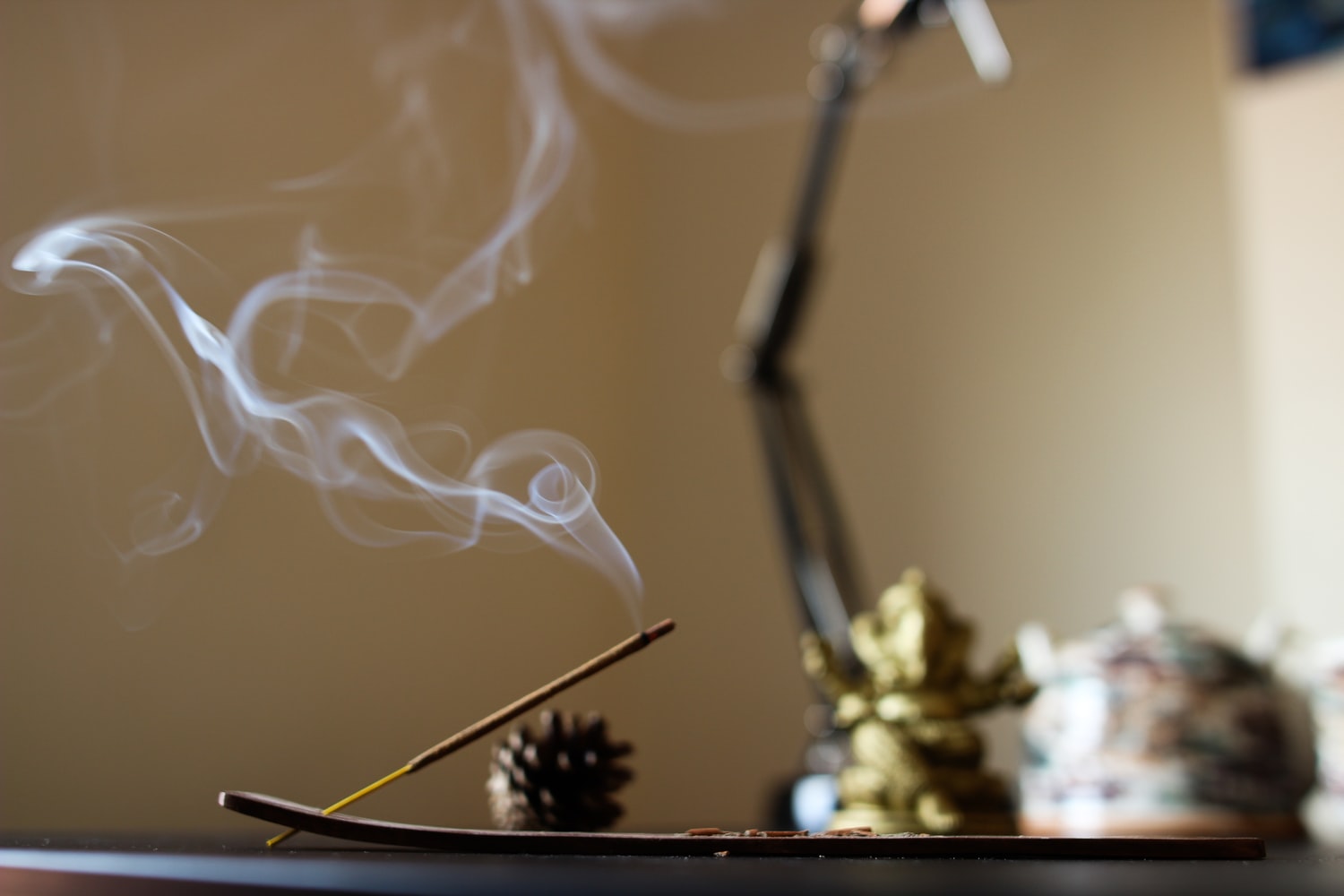 imagem mostra um altar com foco em um incenso queimando