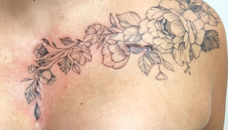 imagem mostra uma tatuagem no ombro e no peito com flores em linha preta