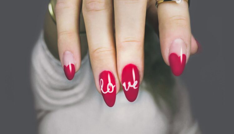 imagem mostra unhas com nail art escrito "love"