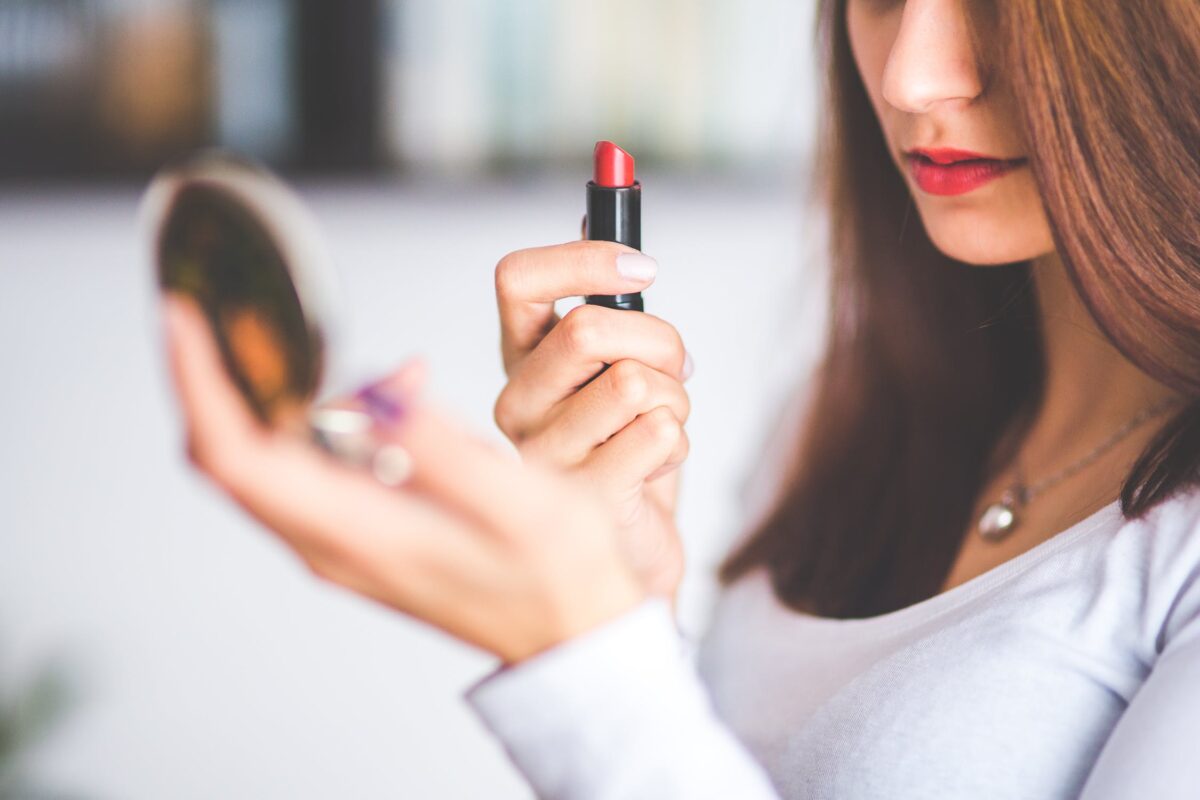 imagem mostra mulher passando batom