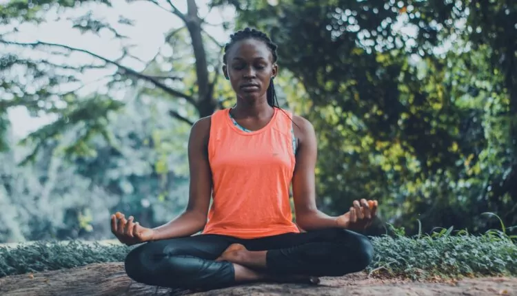 imagem mostra mulher em postura meditativa em Música para meditação espiritual