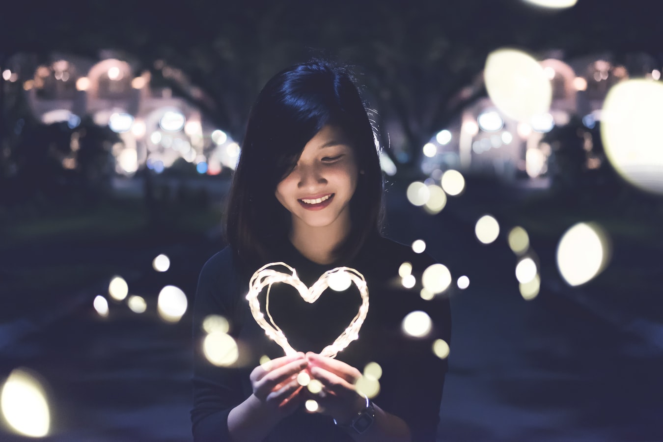 imagem mostra mulher segurando um coração iluminado