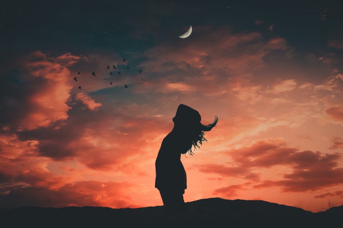 mulher em frente ao céu anoitecendo
