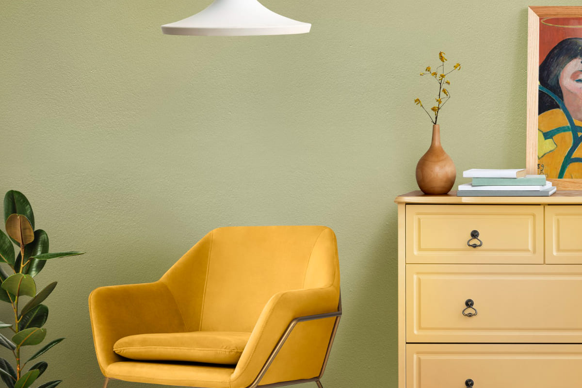 Sala de estar com poltrona amarela, cômoda de madeira e luminária branca