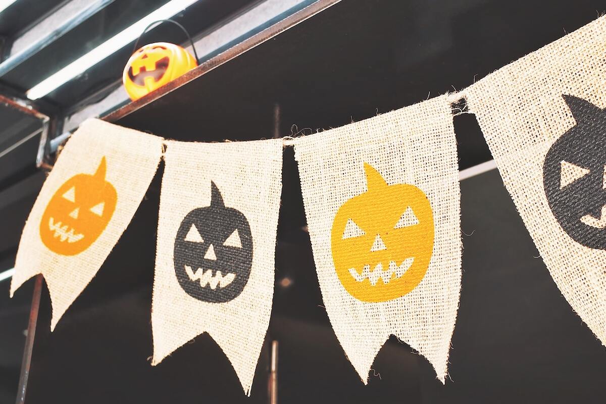 bandeirinhas de halloween com abóboras pintadas em cada uma nas cores preto e laranja