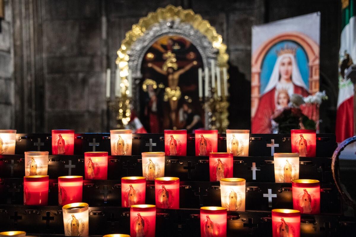Imagem de um altar com velas, acesas em uma igreja