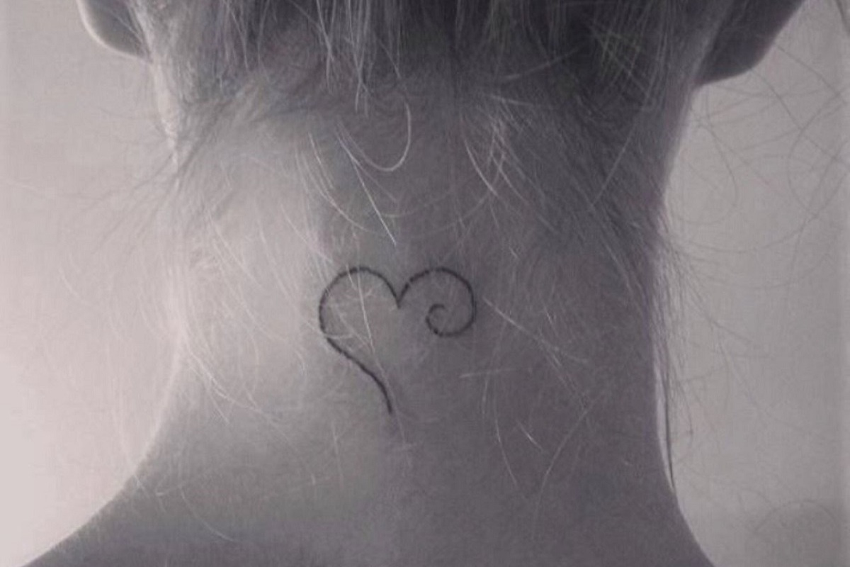 Imagem de uma nuca feminina com uma tatuagem de coração