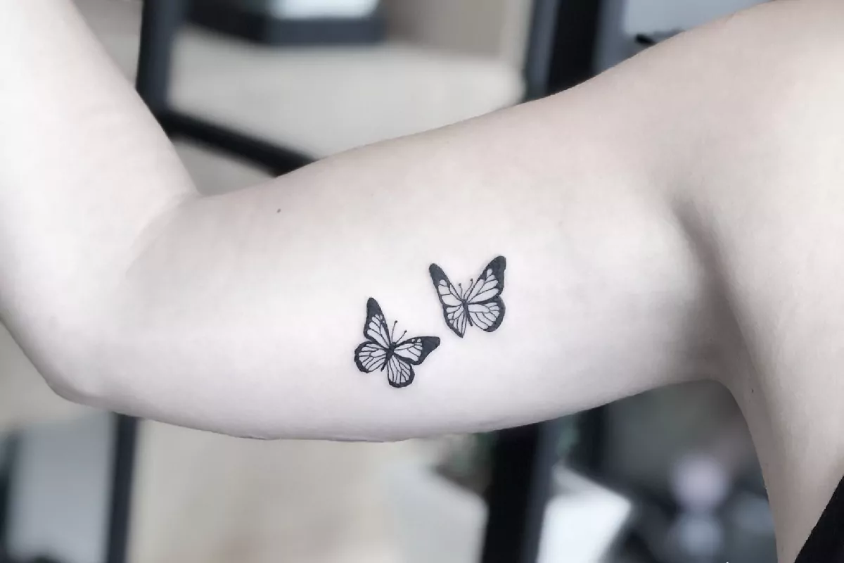 Imagem de um braço feminino com duas tatuagens de borboleta