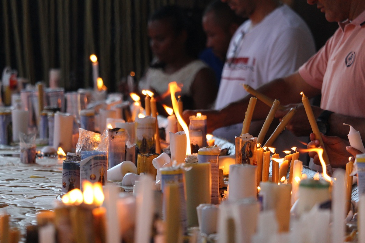 várias pessoas acendendo velas em um espaço de oração