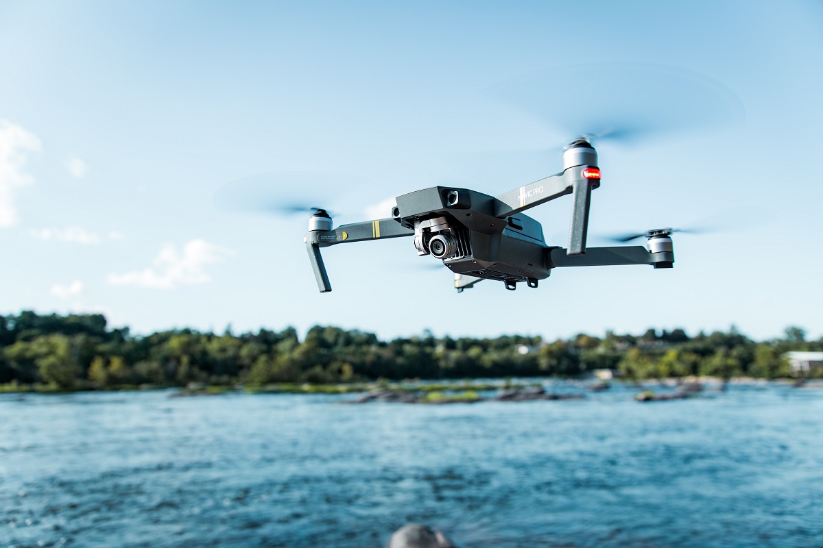 drone cinza voando sobre a água