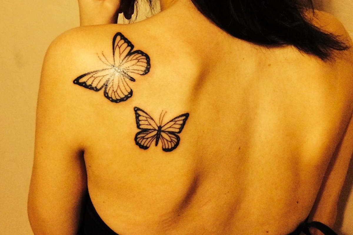 Tatuagem de borboleta nas costas de mulher em região do ombro