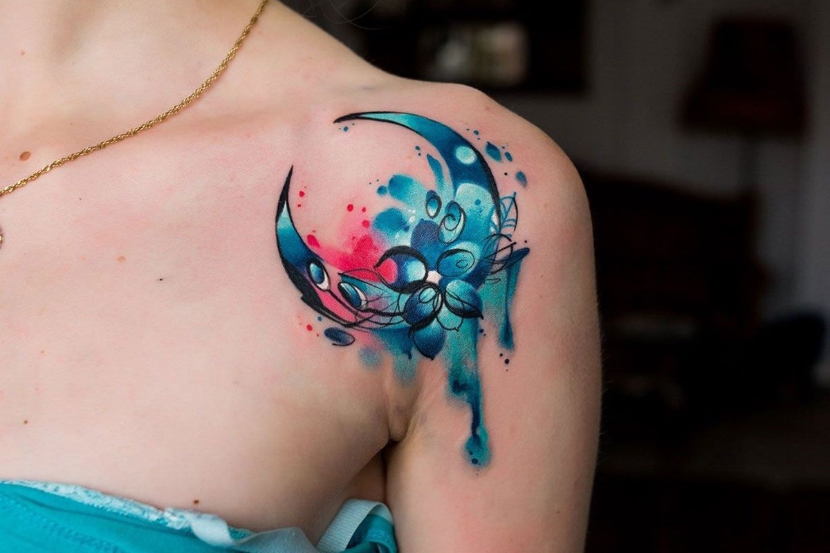 Tatuagem feminina no ombro de mulher com tons em azul