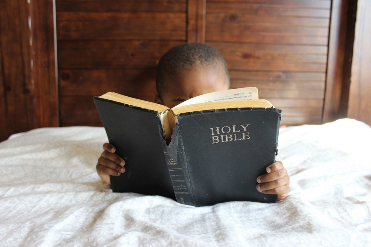 menino lendo a bíblia