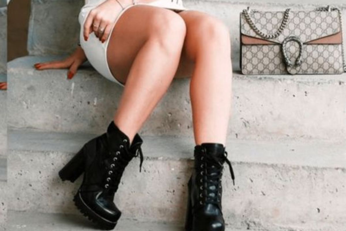 Botas: A imagem mostra uma mulher branca usando saia e também botas pretas