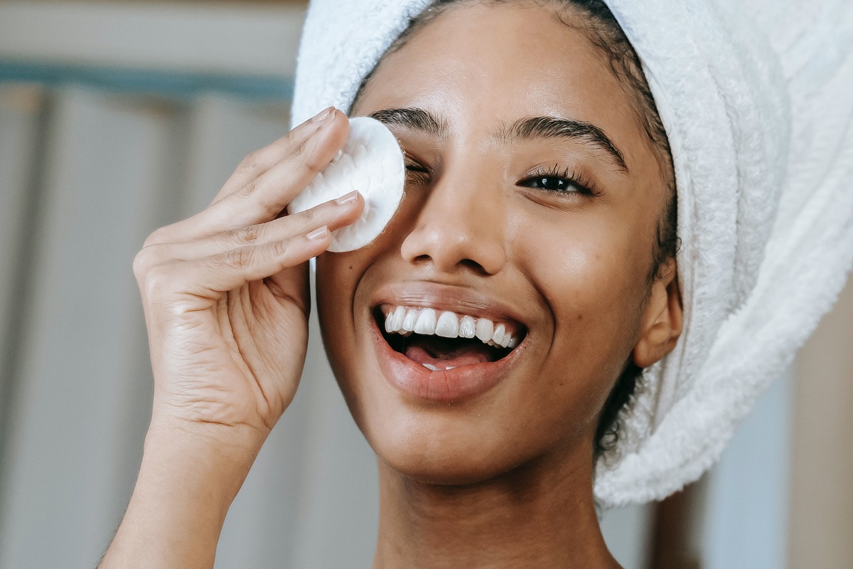 Cuidados com a pele: A imagem mostra uma mulher negra fazendo limpeza de pele. 
