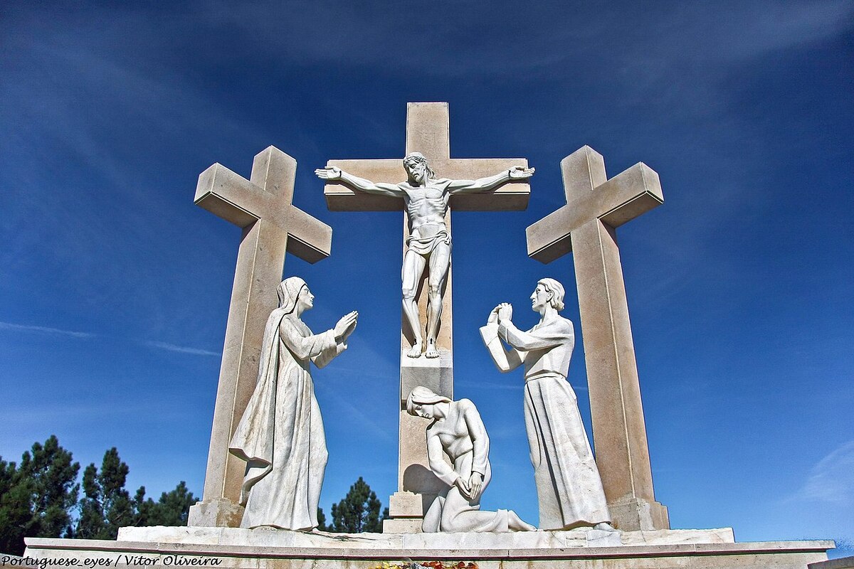 Oração Nossa Senhora de Fátima: A imagem mostra três cruz, sendo que ao meio está uma estátua que representa Jesus. Na imagem também estão três estátuas 