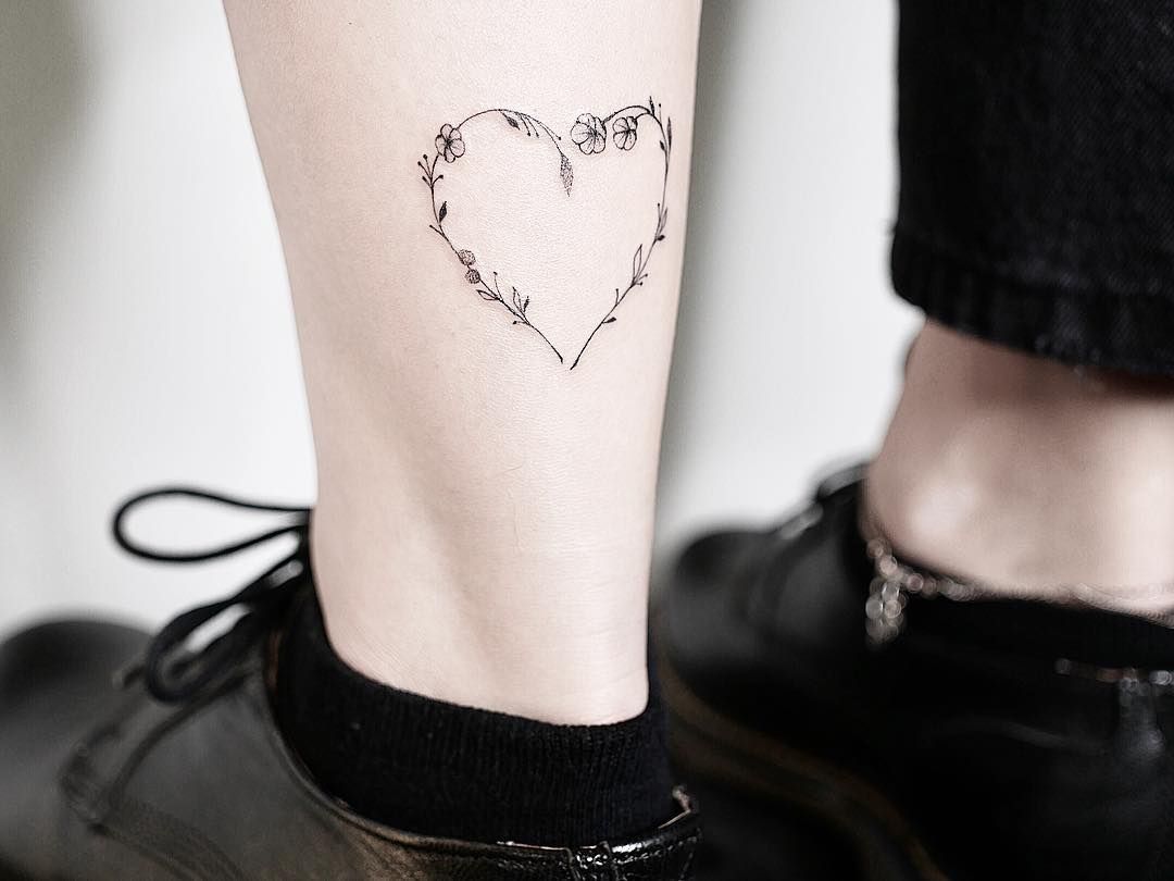 mulher com tatuagem de coração na perna