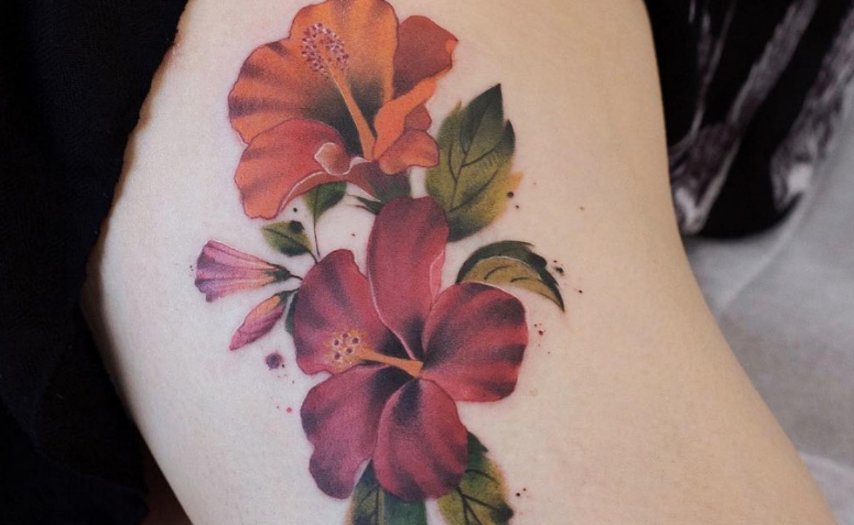 mulher com tatuagem de flor na coxa