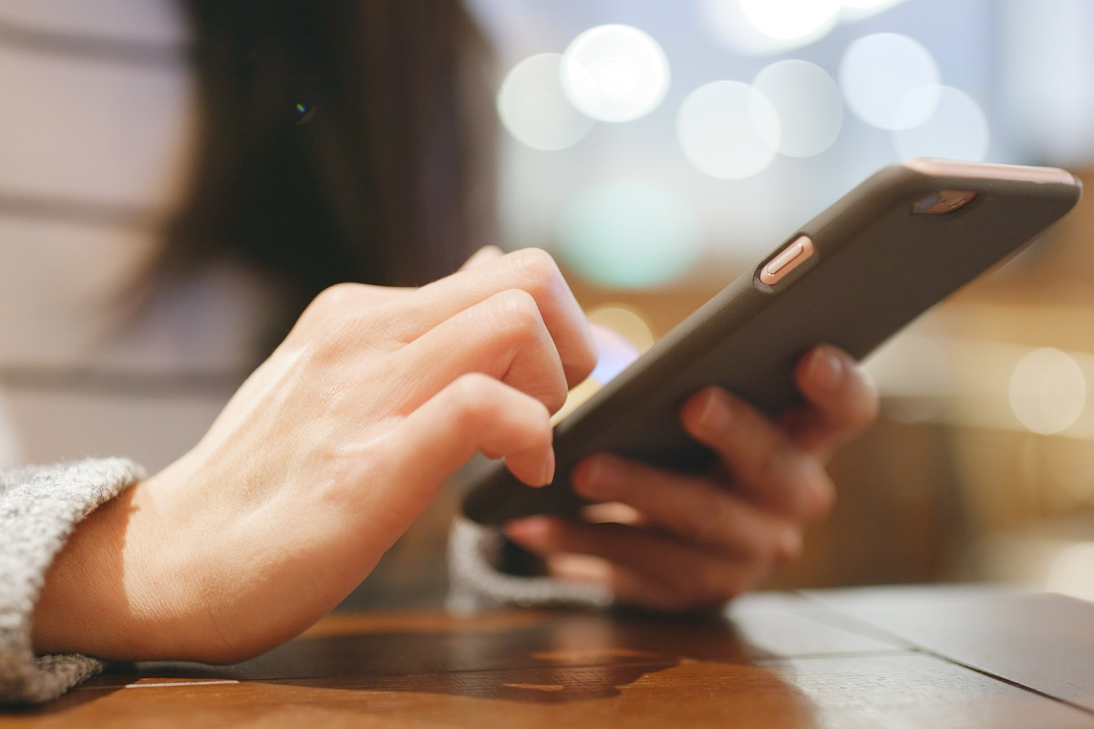 Mulher digitando frases em um celular