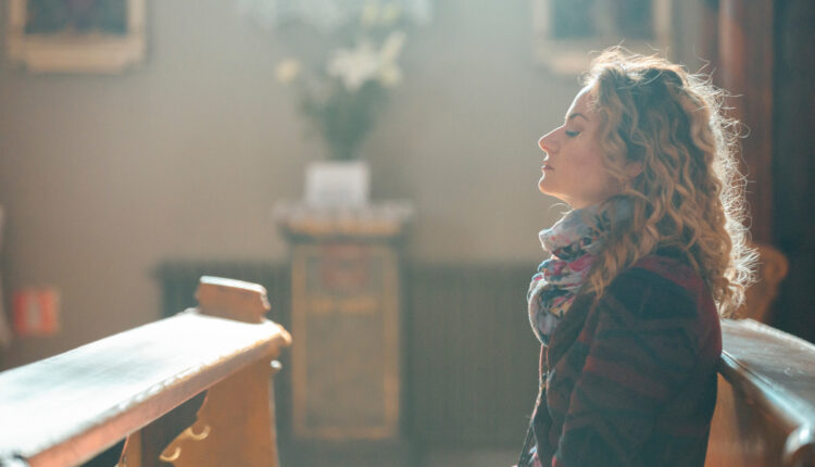 Mulher loira em oração em igreja durante a Quaresma