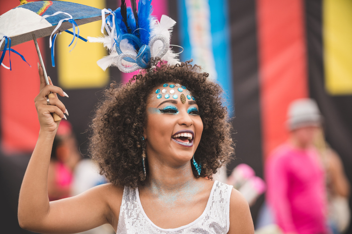 Mulher feliz em Carnaval; legenda de Carnaval pode impulsionar suas fotos