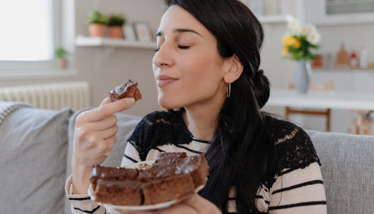 Legenda para foto de bolo nas redes sociais; na foto, mulher saboreando uma fatia de bolo