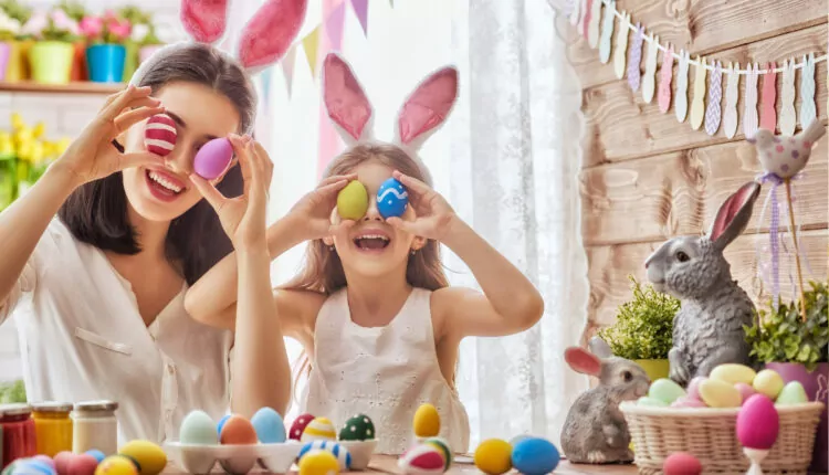 Mãe e filha se divertindo fazendo lembrancinha de Páscoa: ovos coloridos