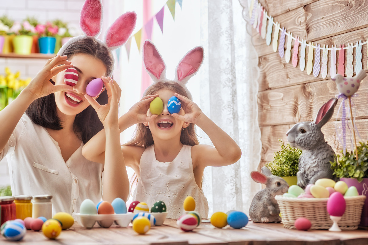 Mãe e filha se divertindo fazendo lembrancinha de Páscoa: ovos coloridos