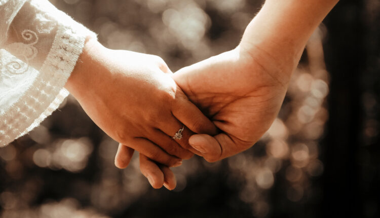 Casal de mãos dadas em oração