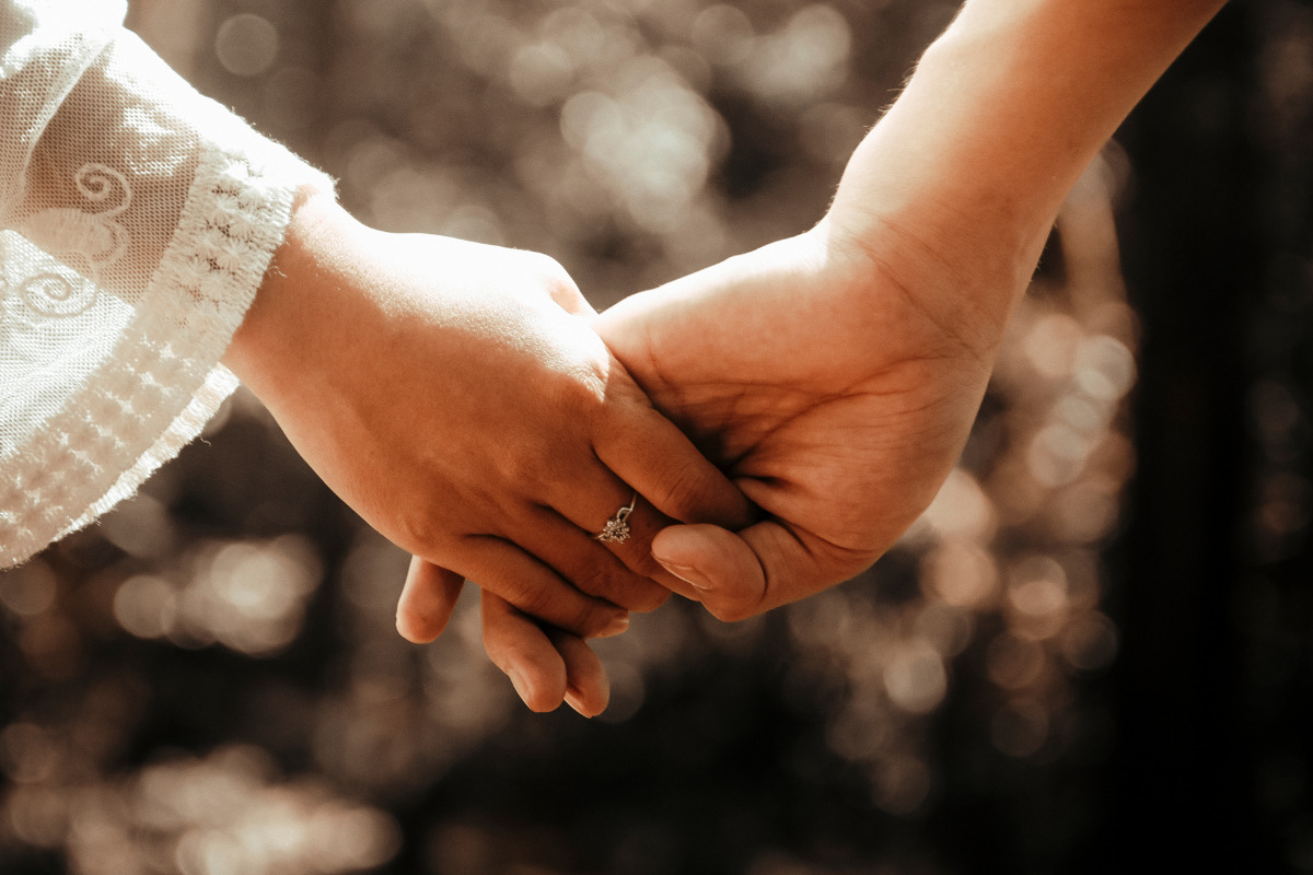 Casal de mãos dadas em oração