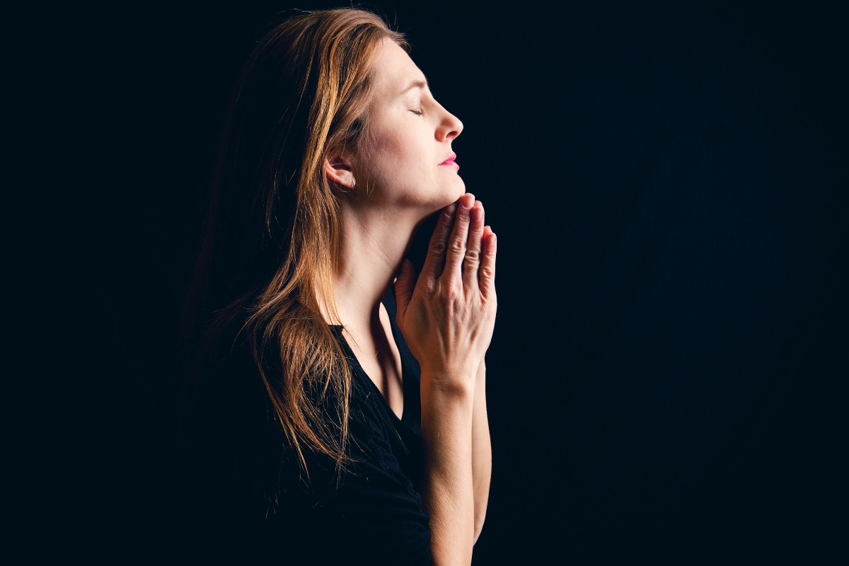 Mulher em oração em momento de desespero