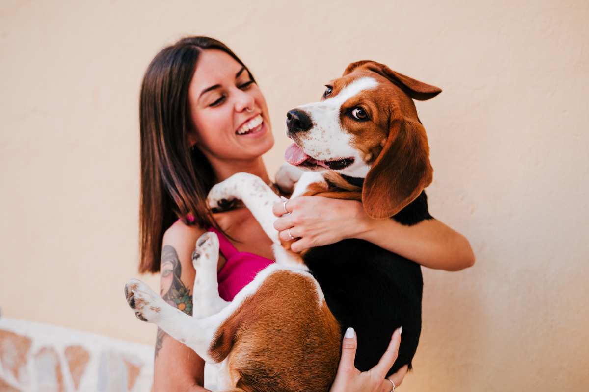 Mulher com cachorro no colo; veja 60 frases sobre animais